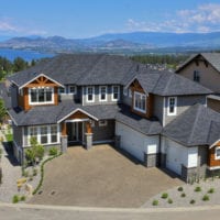 Aerial view of a custom home build by Stark Homes in Kelowna, with Okanagan Lake in the background
