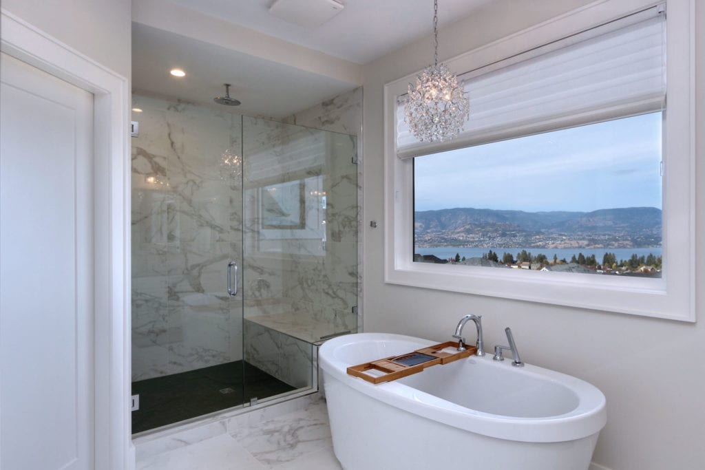 Luxury custom bathroom with large window overlooking kelowna and okanagan lake, built by Stark Homes