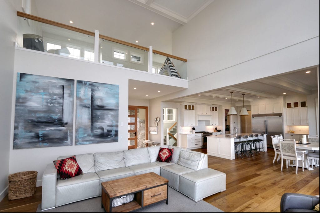 an open-concept living room and kitchen built by Stark Homes, integrating the custom home trend of natural wooden accents